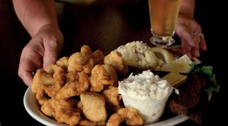 Two hands presenting a plate of food