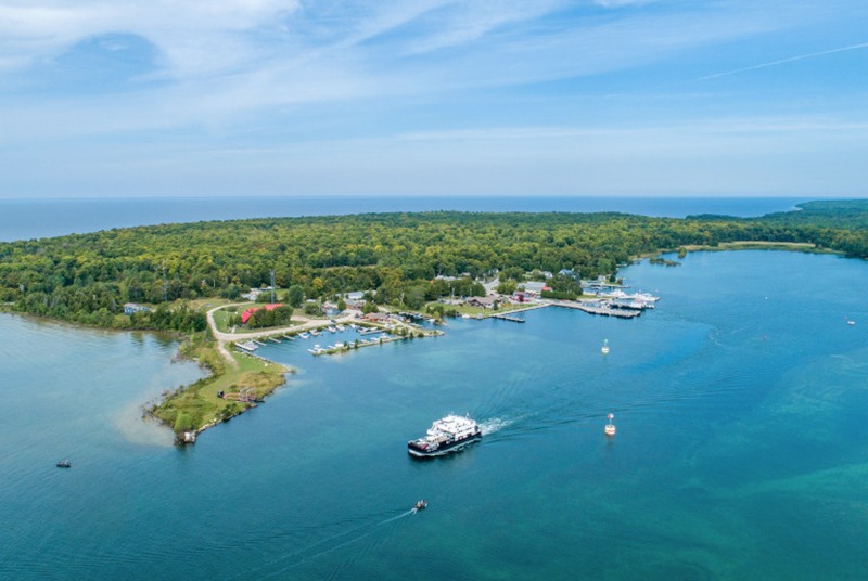 Aerial shot of a tree-covered peninsula with boats