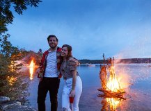 Couple in front of a bonfire at the lake.