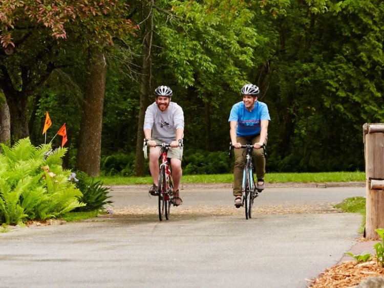 Two people riding bikes down a path.