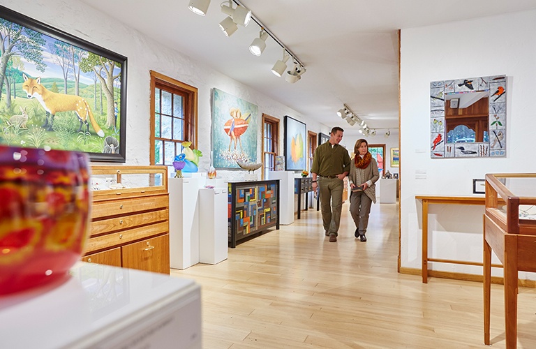 A couple walking through an art gallery.