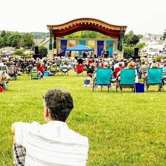 People sitting outdoors watching a show.