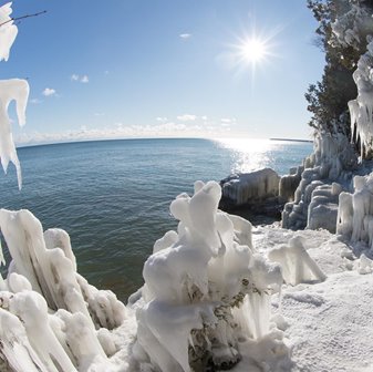 Snow-covered trees lining the lakefront.