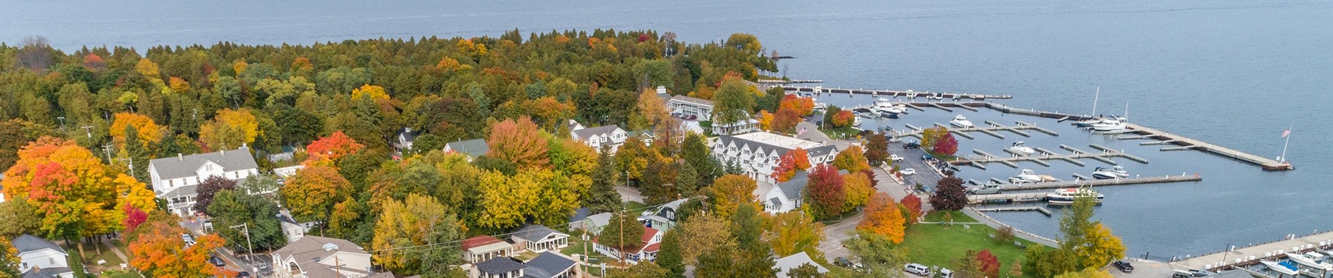 A town and marina surrounded by trees in their fall colors