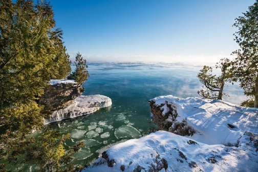 Snow and icy cliffside looking out to the lake with ice floating in it