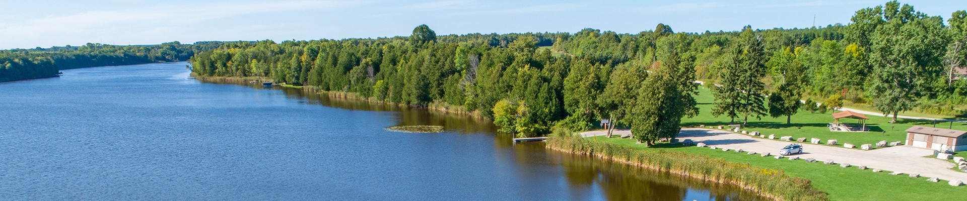 A waterway surrounded by trees stretching into the distance.