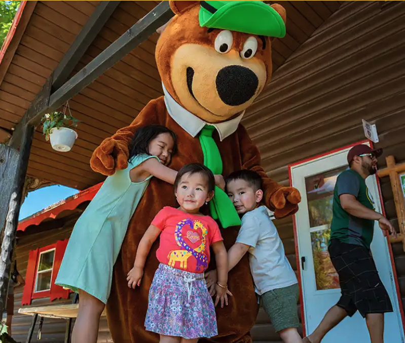 children hugging Yogi Bear