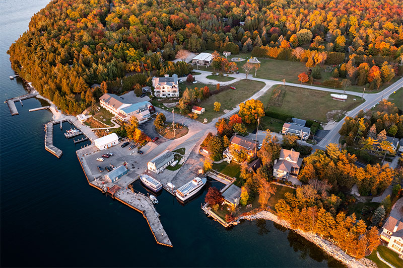 A Door County city along the water during the fall with beautiful trees.