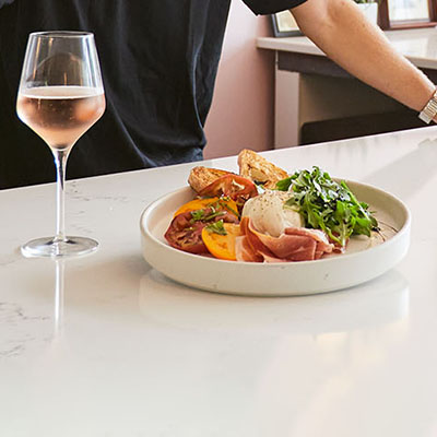 A plated dish next to a glass of wine