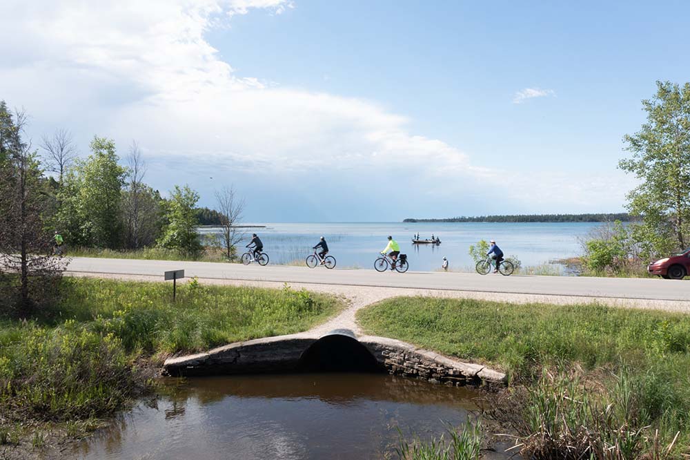 People biking over a land bridge