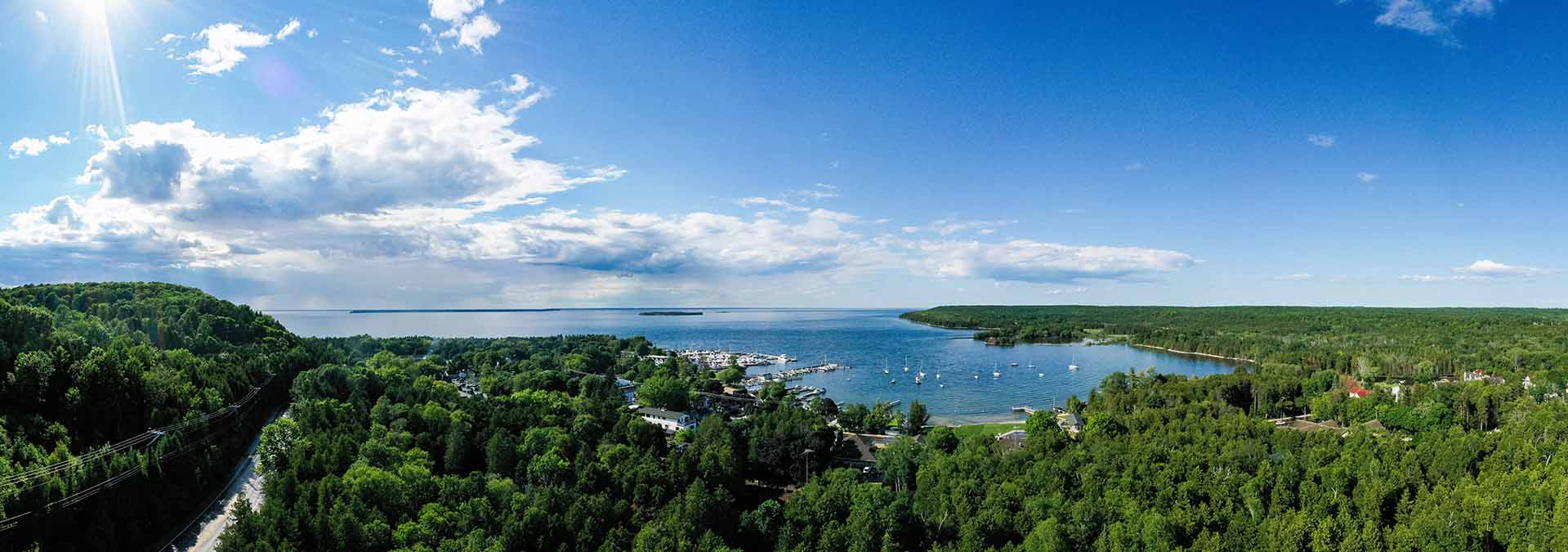 Sunny blue sky day, aerial view overlooking a wooded area.