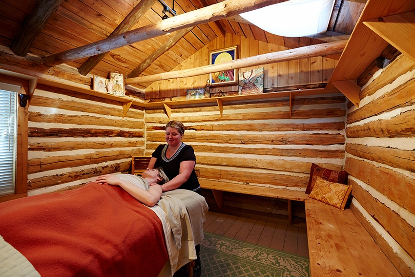 A women gets a massage in a calming wooded room