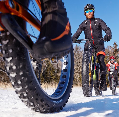 Mountain bikers riding through the snow.