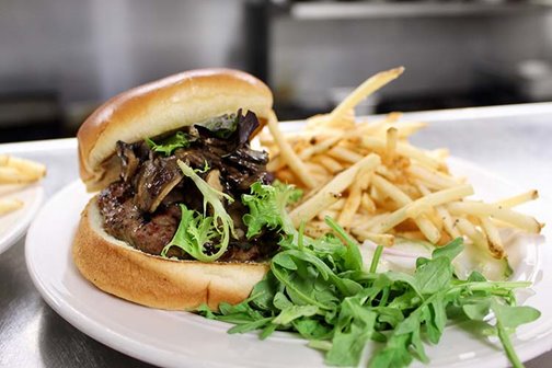 A burger with french fries on a plate.