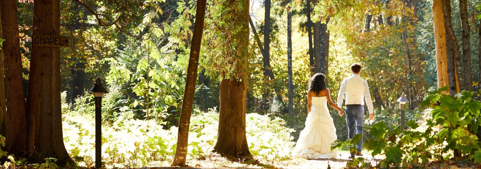 Bride and groom walking down a path through the woods