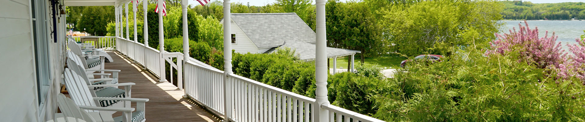 A massive covered porch wraps around an old-fashioned hotel on the water.